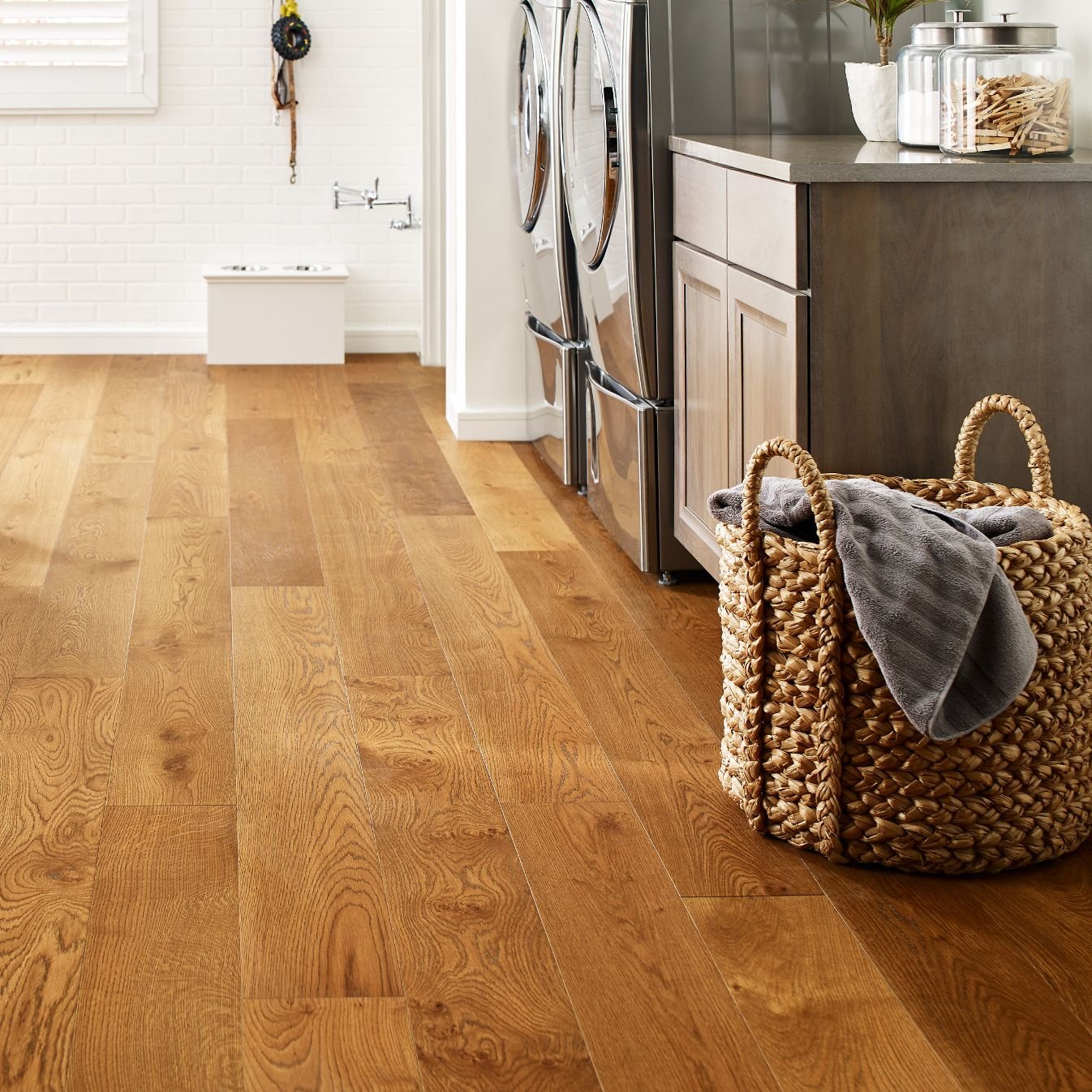 Basket of laundry in a kitchen with wood-look luxury vinyl flooring from Triangle Flooring Center in Carrboro, North Carolina