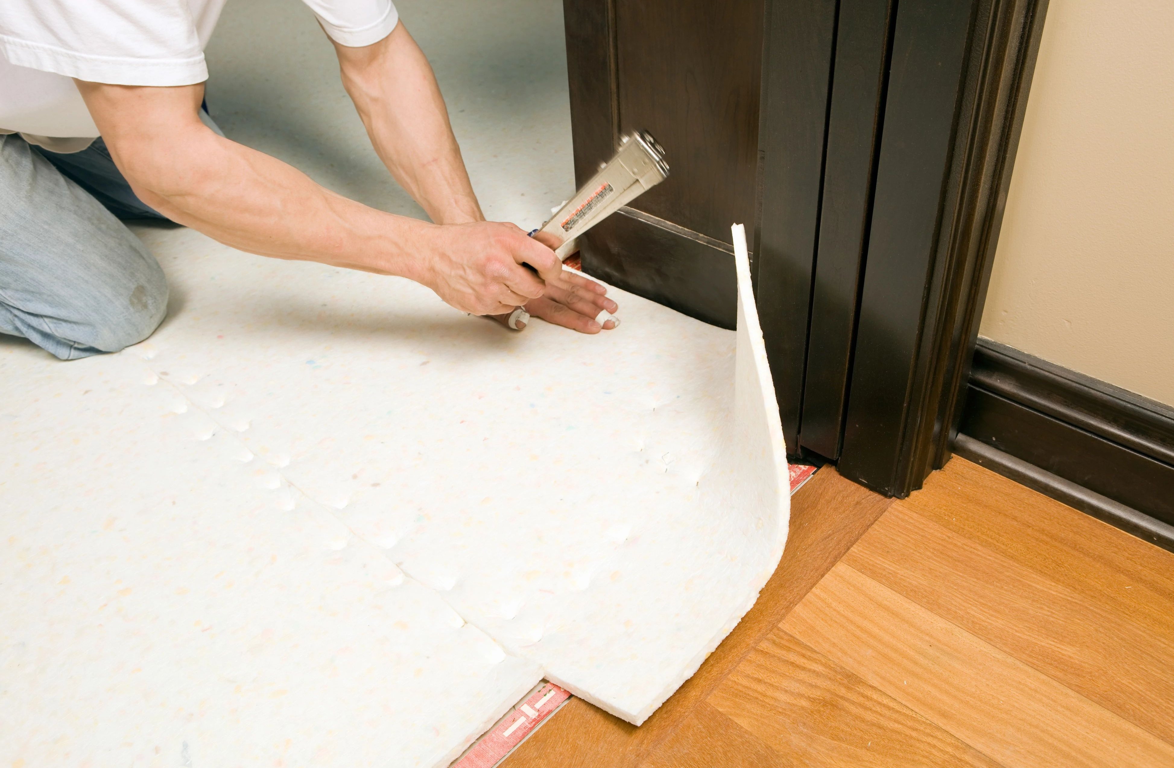 Person installing flooring underlayment from Triangle Flooring Center in Carrboro, North Carolina