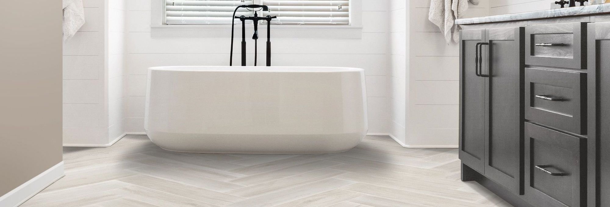 Tiled bathroom with a white bathtub - Triangle Flooring Center in Carrboro, North Carolina